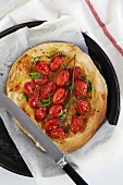 Cherry tomato pizza with basil on baking tray