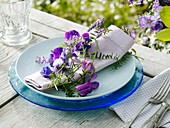 Place-setting with sweet peas and vetch on napkin