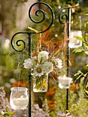 Blumenstrauss in Vase und Windlichter an Dekostab aufgehängt