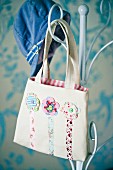 Girl's bag with floral motifs hanging on metal coat stand