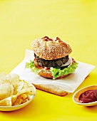 Burger with ketchup and potato crisps