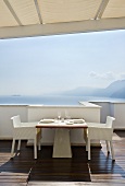 Laid table on terrace with sea view (Casa Angelina, Italy)