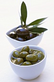 Green and black olives in small bowls