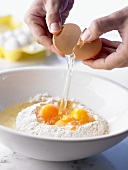 Breaking eggs into flour