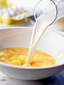 Stirring milk into beaten eggs