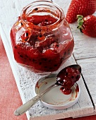 Strawberry and passion fruit jam in jar and on spoon