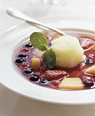 Cold fruit soup with a scoop of sorbet in the middle