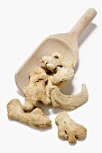 Pieces of dried ginger root with a wooden scoop