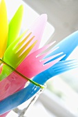 Coloured plastic cutlery in a glass