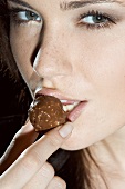 Young woman eating a chocolate