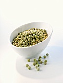 Green dried peas in and in front of a bowl