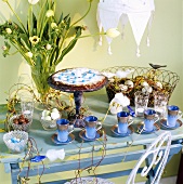 Cups, cake, vase of tulips and eggs on Easter table