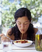 Eine Frau mit einer Spaghetti im Mund