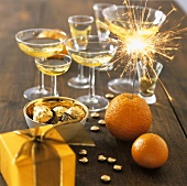 Orange with sparkler, chocolates, glasses of sparkling wine
