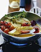 Fennel and tomatoes in saffron broth in a frying pan