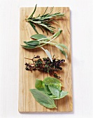 Basil, thyme, sage and rosemary on wooden board