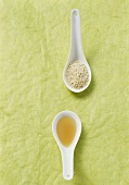 Sesame seeds and sesame oil in spoons