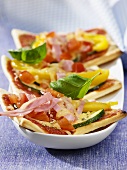 Three pizza slices with ham and vegetable topping