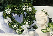 Heart-shaped green wreath with white carnations, lace bows