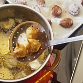 Deep-frying Nonnenfürzchen (choux pastry balls)
