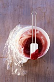 Red jam in small bowl and on spatula