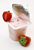 Strawberry yoghurt in opened yoghurt pot