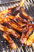 Brushing spare ribs on the barbecue with marinade