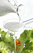 Yoghurt vinaigrette running over spoon onto salad