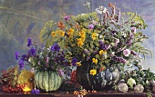 Two arrangements of herbs in pumpkins