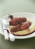 Bacon-wrapped sausages with polenta