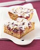 Two pieces of raspberry cake with almonds