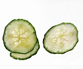 Three slices of cucumber on white background