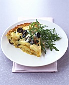 A piece of tortilla with olives and rocket