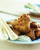 Crispy fried chicken pieces and celery with dip