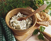 Herb butter in a bowl with a wooden spoon