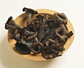 Black chanterelles in a wooden dish