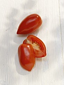 One whole and one halved plum tomato