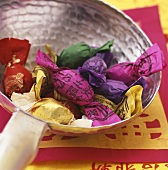 Sweets in coloured wrappers in a dish