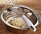 Creamed butter in a bowl with whisk