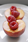 Two peach halves filled with raspberries