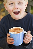 Boy holding cup of hot chocolate