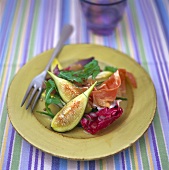 Ham and figs on salad leaves