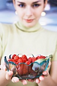 Woman holding a bowl of raspberries