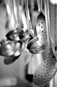 Ladles and slotted spoons hanging up in a kitchen