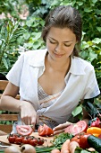 Young woman cutting up tomatoes