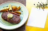 Rump steak with herb butter and baked potato wedges