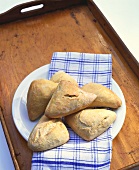 Bread rolls on a plate with checked tea towel