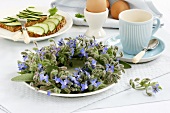 Borage wreath on breakfast table with egg & cucumber on bread