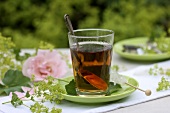 A glass of lady's mantle tea with swizzle sugar stick
