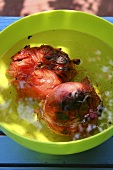Grilled tomatoes in a bowl of water
